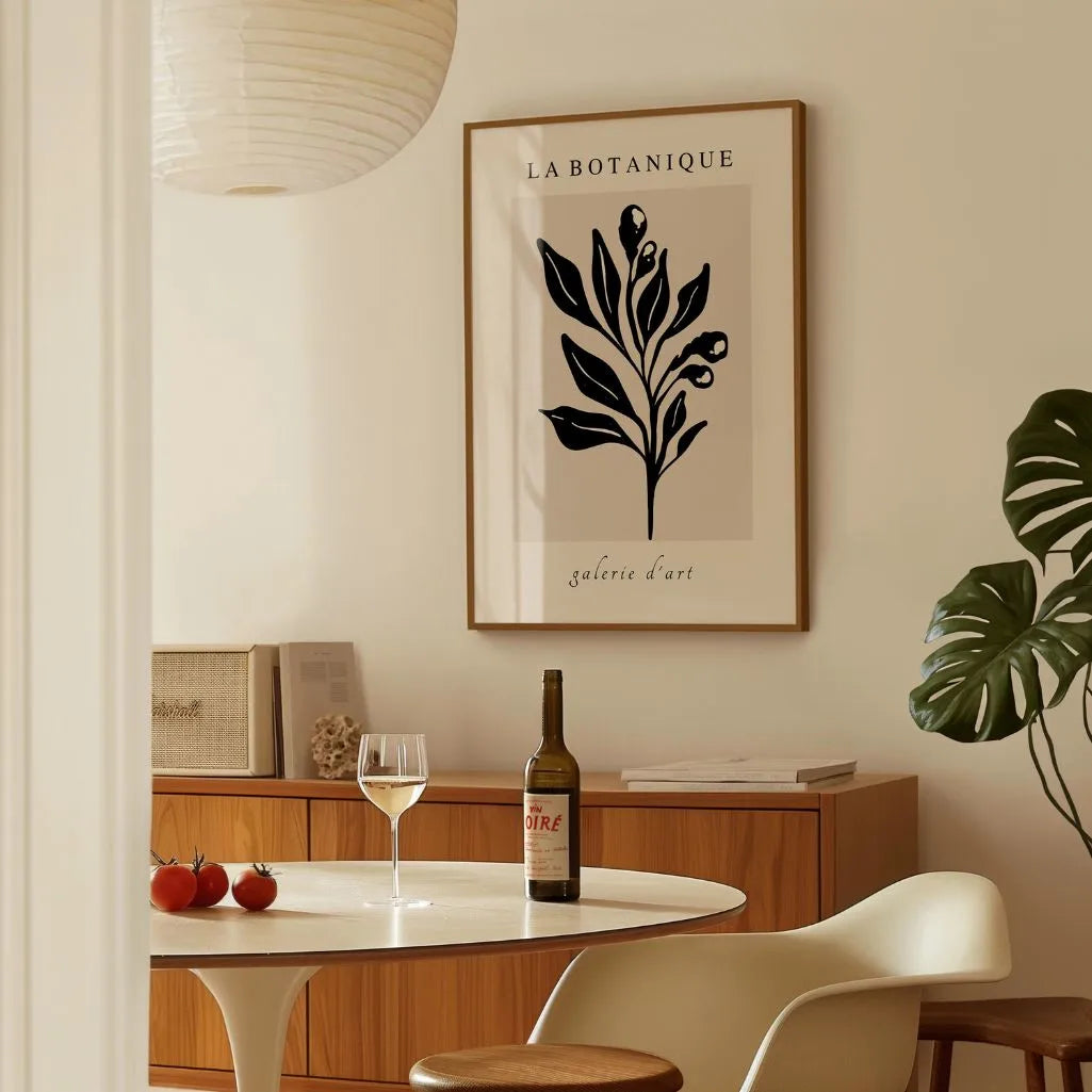 Black botanical leaves poster displayed in gallery wall with minimalist neutral artwork